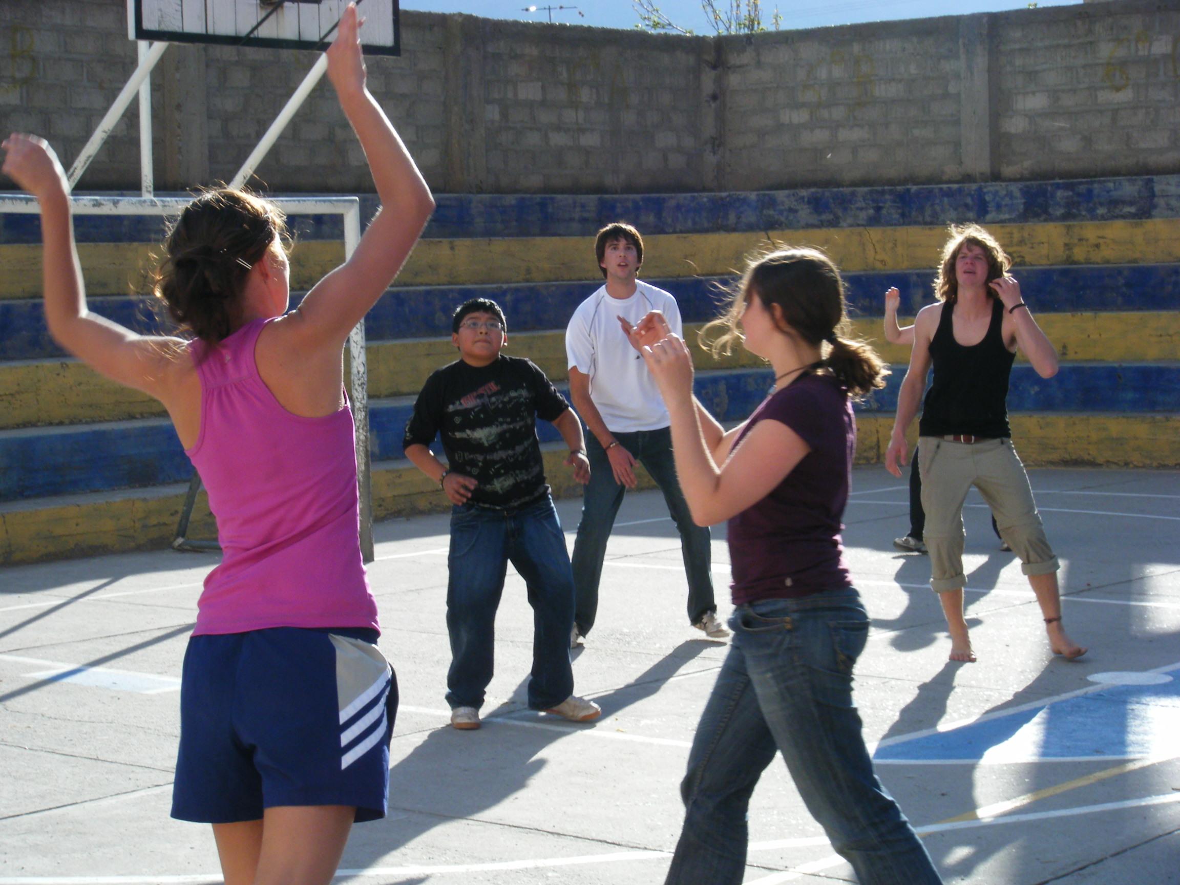 Voluntaria de Projects Abroad le enseña a su equipo de básquetbol cómo defender durante su voluntariado deportivo en Perú. Una voluntaria como profesora de deportes en Perú hace demostraciones a su equipo.